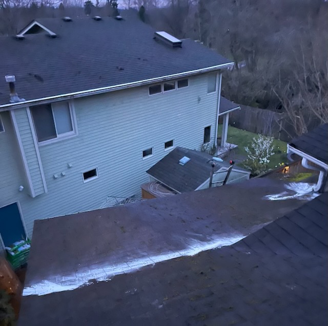 Elevated view of a two-story Washington home roof on a frosty morning